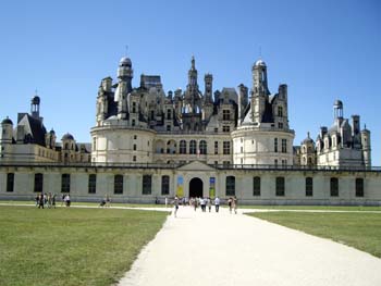 Fachada principal del Castillo de Chambord con visitantes caminando por el sendero