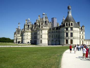 Castillo de Chambord en Francia con turistas caminando por el sendero en un día soleado
